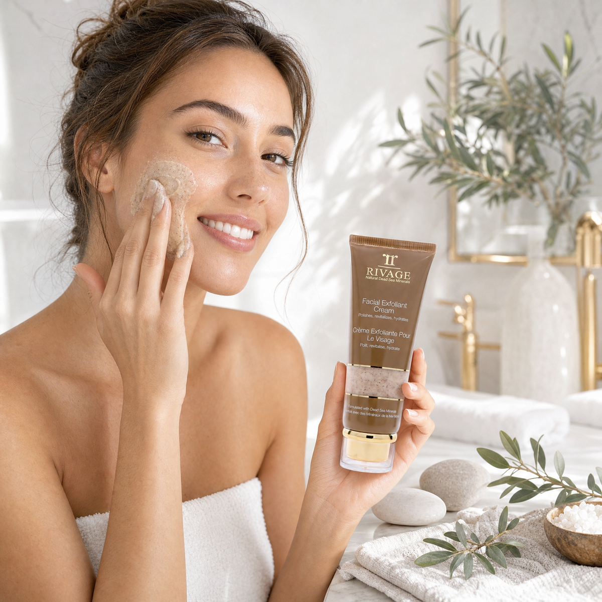 Woman massaging Rivage Facial Exfoliant Cream onto her cheek holding the 100 ml tube